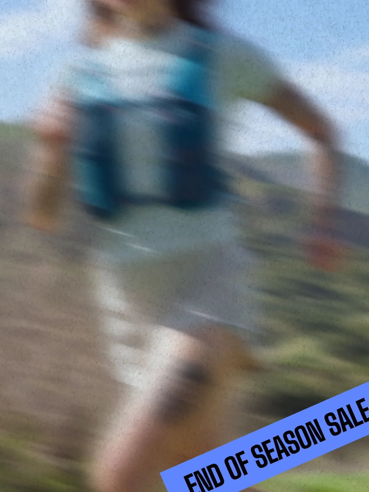Three trail runners are seen from behind running on a dirt path through tall grass, wearing NATHAN hydration packs and athletic clothing.