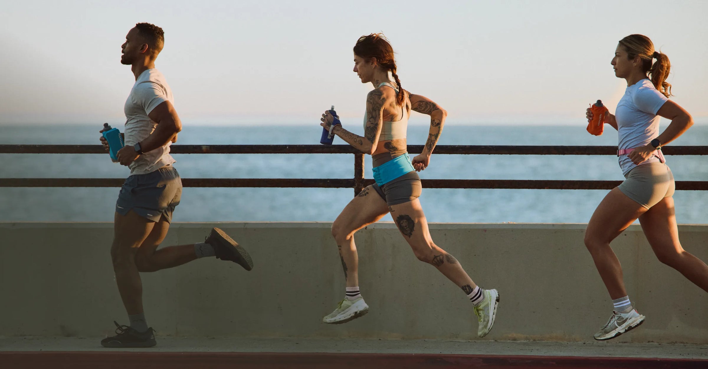 Three people running holding SpeedDraw 2 Insulated flasks
