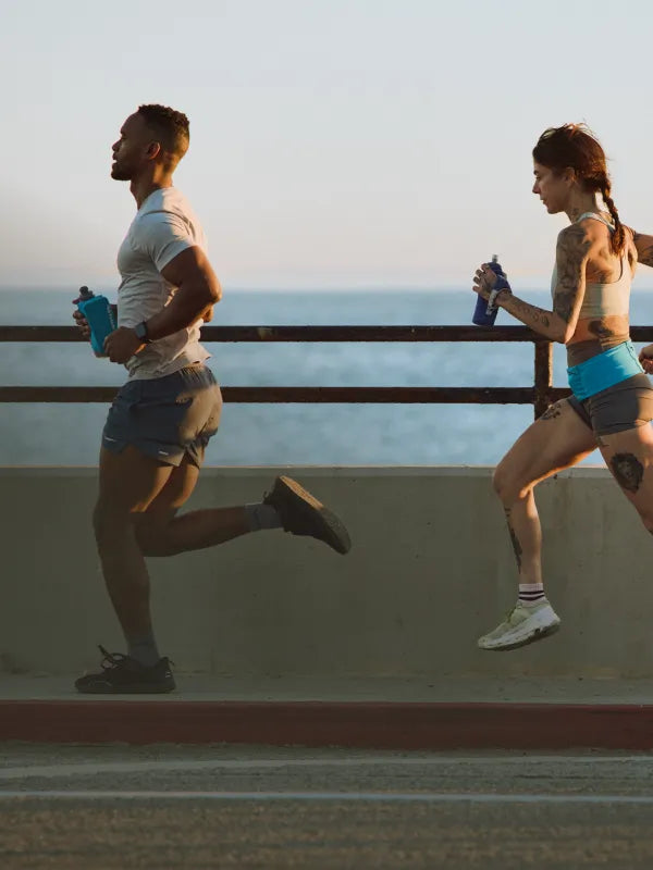 Three people running holding SpeedDraw 2 Insulated flasks